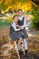 Portrait of schoolgirls in school uniforms having fun in the autumn landscape