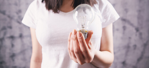 Fototapeta na wymiar young woman holding a light bulb