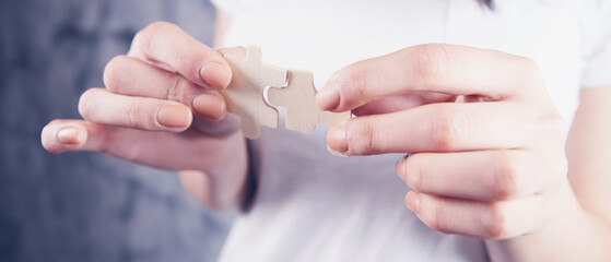 woman holding two puzzle pieces