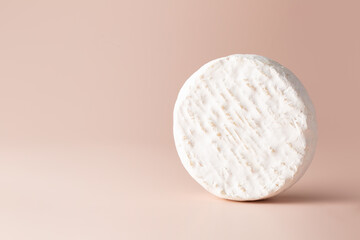 Cheese with white Camembert mold on a light pink background. Copy space. Place for text.