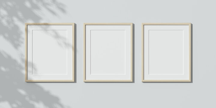 Three wooden frames on white wall. Triptych. 3D render wooden frame mock up. Empty interior. 3D illustrations. 3D design interior. Template for business. Passe partout frame. Shadow on the wall.	

