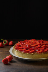 Homemade strawberry pie with syrup on a ceramic platter.
