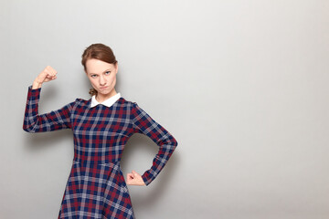 Portrait of proud rebellious woman posing with fists like bodybuilder