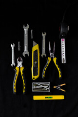 Maintenance, construction tools on black, dark background.