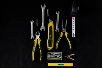 Maintenance, construction tools on black, dark background.