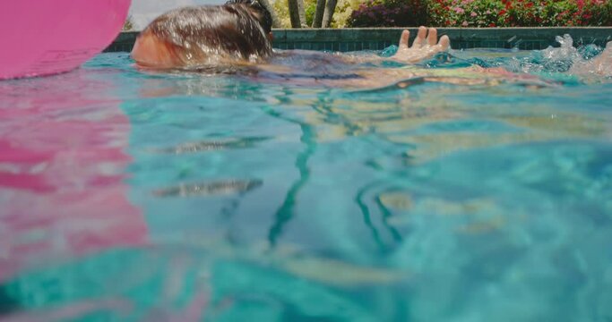 Family playing in the pool, young boy swimming underwater, summer vacation lifestyle concept