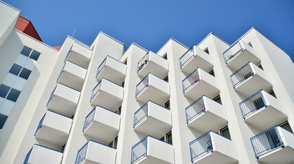 Modern white facade of a residential building with large windows. View of modern designed concrete...