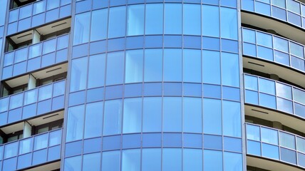 Fototapeta na wymiar Glass and steel. Mirrored facade of modern office building with blue sky.