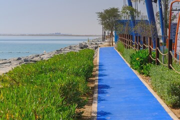 Blue long running track on embankment with special high technology surface for walking and jogging exercise. Rubberised surface provides cushioning and minimises risk of injury. Healthy life concept