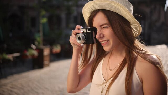 Fashion look, pretty cool young woman model with retro film camera wearing hat