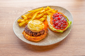 Burgers menu with veal, fried goat cheese, grilled brioche bread and tomato jam with caramelized onion on lettuce and fried garnish potatoes
