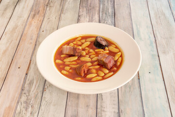 Popular Spanish recipe for Asturian fabada with large white beans, bacon cubes, chorizo chunks and black pudding to cook