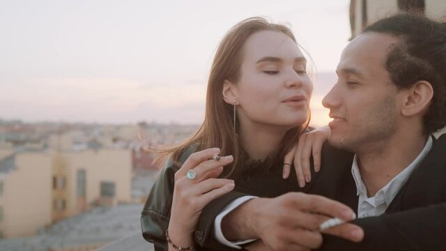 Young Couple smokes Cigarette on the roof