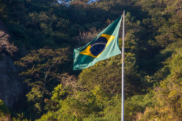 Flag of Brazil outdoors trees in the background in Rio de Janeiro.