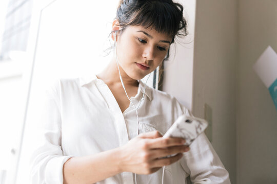Beautiful young Asian woman using a smartphone