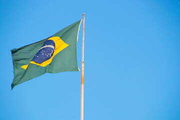 Flag of Brazil outdoors with a beautiful blue sky in the background in Rio de Janeiro.