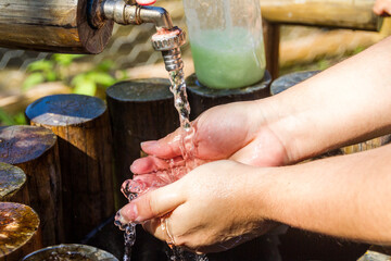 Woman washing her hands outdoors in Rio de Janeiro.