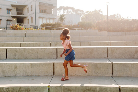 Girl running through concrete amphitheater
