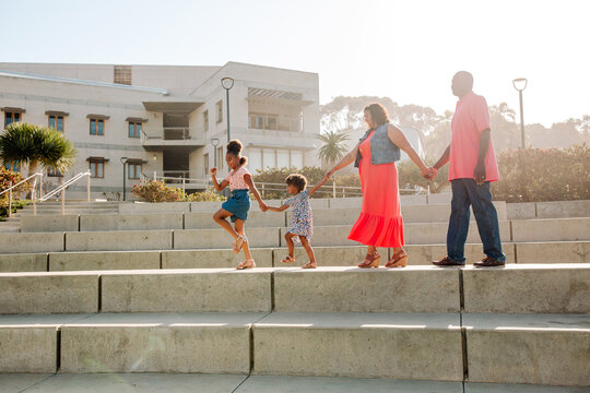 Joyous family marching on concrete steps 