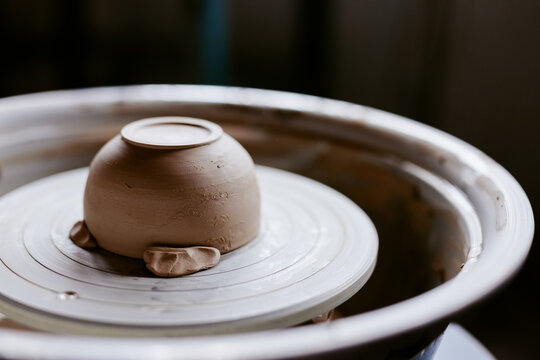 Clay cup on pottery wheel machine