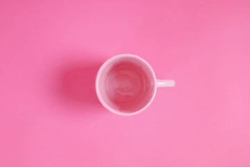 Fototapeta na wymiar Pink cup of water on a pink scene