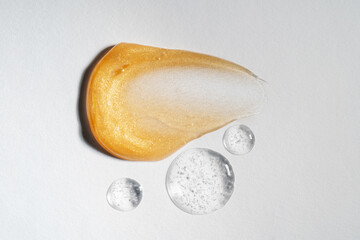 A smear of a golden mask or cream on a white background.
