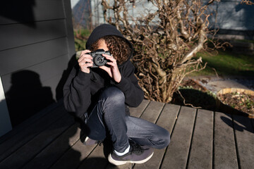 Boy with camera taking photo of viewer
