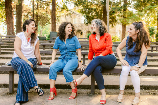 Friendly women laughing together in park