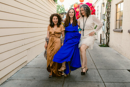Charming mature women in dresses dancing together during party