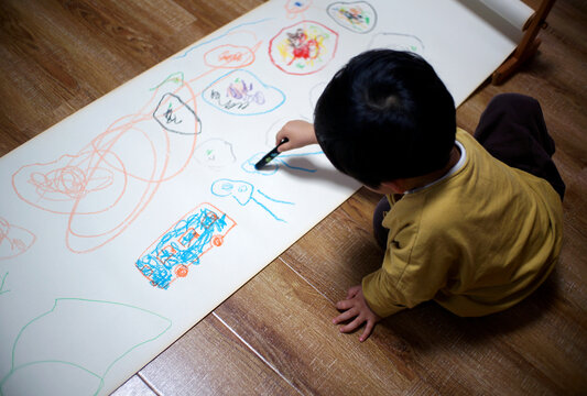 Cute Asian Chinese little boy drawing at home