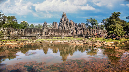 Fototapeta premium Siem Reap, Cambodia - December 2015: The many face temple of Bayon at the Angkor Wat site in Cambodia under dramatic clouds