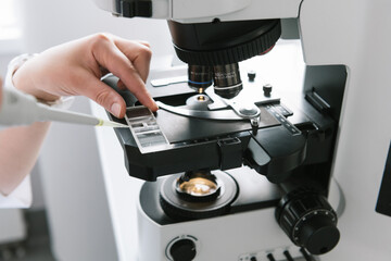 Scientist Using Microscope And Pipette