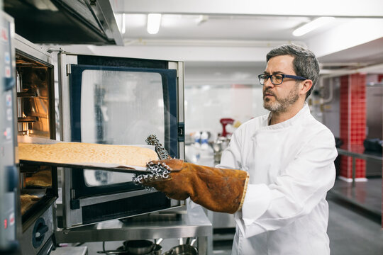 Man placing cooking tray in oven 