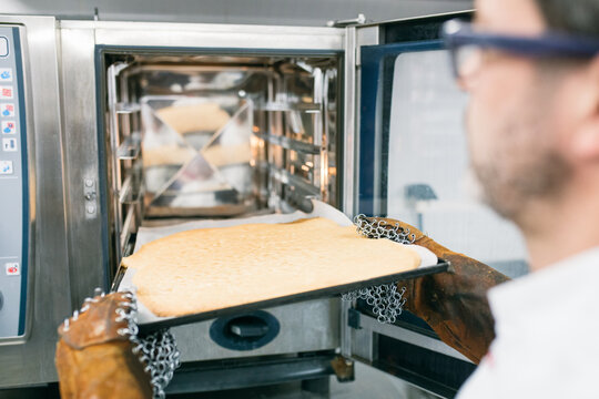 Man placing cooking tray in oven 