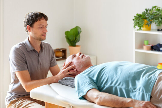 An osteopath applying pressure to patient's head