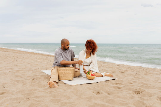 Black couple relaxing on the sand beach - Powered by Adobe