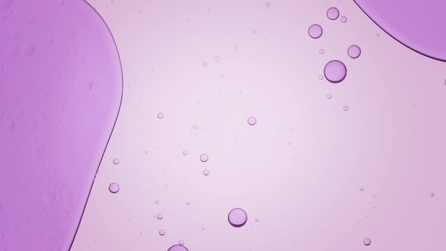 Big purple bubble moves to the left and down in transparent liquid with smaller ones on pale violet background | Background for skincare cosmetics commercial shot