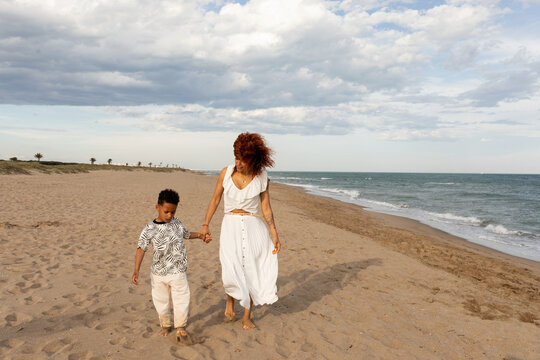 Mother and son walking by the beach in summer