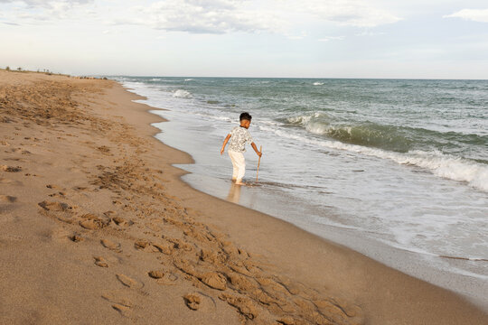 Little kid walking along the seashore