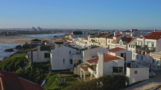 Baleal, Portugal, Europe. Beautiful coastal cottages with a seascape in the background. Aerial view of a beach by the seaside town as seen from top. High quality 4k footage