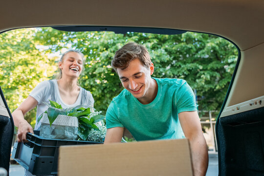 Man and Woman Taking Things Out of Trunk 