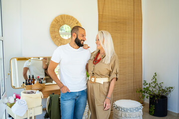 Mother and adult son embracing smiling together at home