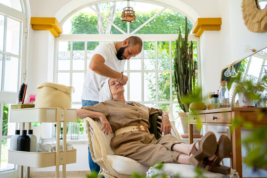 Senior woman getting a facial treatment at home