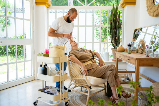 Senior woman getting a facial massage at home