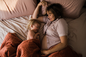 pregnant mother in bed with toddler