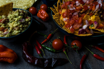 mexican food nachos with pico de gallo cheese and guacamole in bowl darkfood style