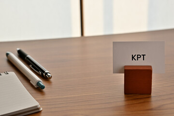 There is a card on paper stand with the word of KPT which is an abbreviation for Keep Problem Try on the desk with a pen.