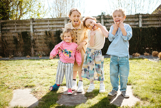 Group portrait of 4 siblings making funny faces