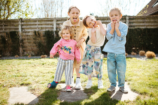 Naklejki Group portrait of 4 siblings making funny faces
