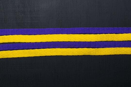 Yellow And Purple Shoelaces, Lakers Flag, On Black Wooden Background, Leaving Space For Advertising Text